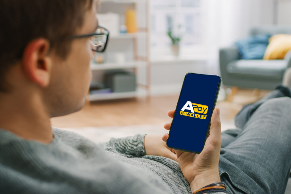 Android Wallet App: ragazzo seduto sul divano che utilizza app APay E-Wallet con logo