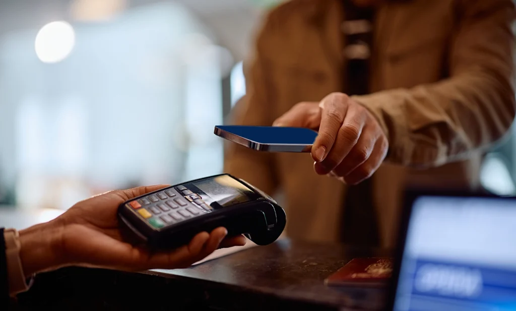 Vantaggi di apay card: ragazzo paga in negozio con pos